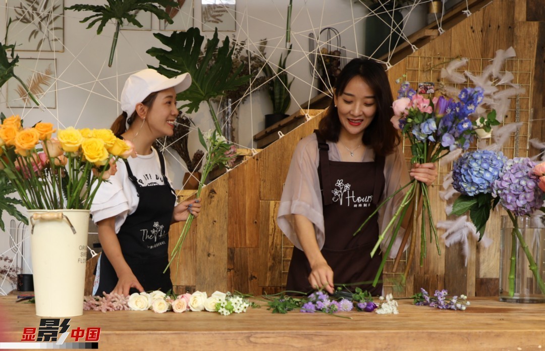 “昆明是鮮花的原產地，有亞洲最大的鮮切花交易市場，可以說具備開花店的天時地利；另外和很多女孩一樣，我從小也就有開花店的夢想！”說起當初的決定，王黎媛說一是因為夢想，另外也跟昆明這個城市產花、賣花的“基因”有關。圖為王黎媛和同事在制作花束。新華網 周亞平/攝 念新洪/文